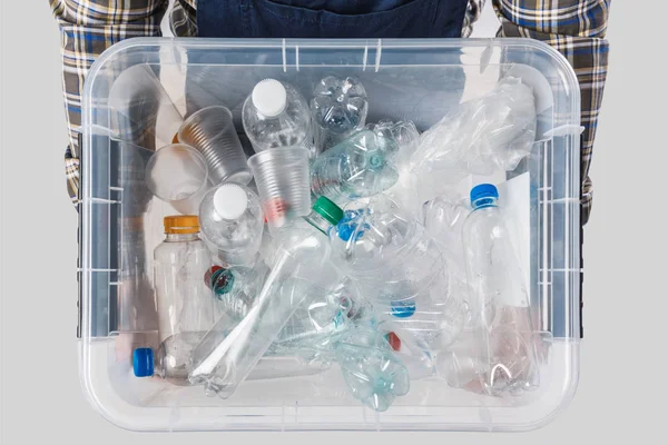 Partial view of man holding container with plastic bottles in hands isolated on grey, recycling concept — Stock Photo