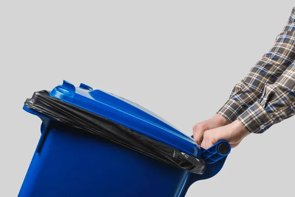 Partial view of cleaner with trash bin isolated on grey — Stock Photo