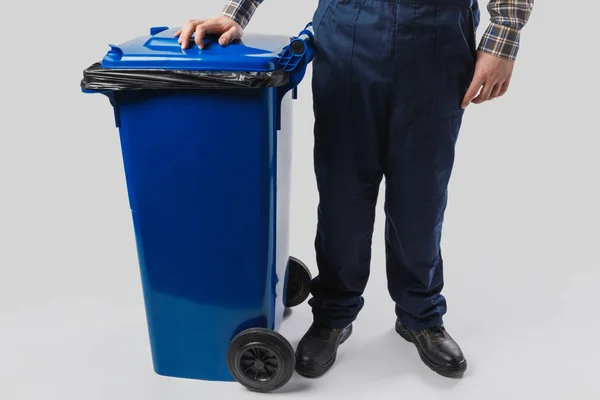 Partial view of cleaner with trash bin isolated on grey — Stock Photo