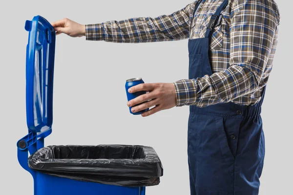 Partial view of cleaner putting can into trash bin isolated on grey — Stock Photo