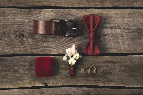 Flat lay with arranged grooms accessories and wedding rings on wooden tabletop — Stock Photo