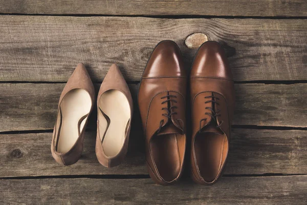 Vista superior de novios y novios pares de zapatos en la superficie de madera - foto de stock