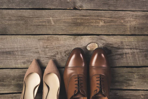 Top view of bridal and grooms pairs of shoes on wooden surface — Stock Photo