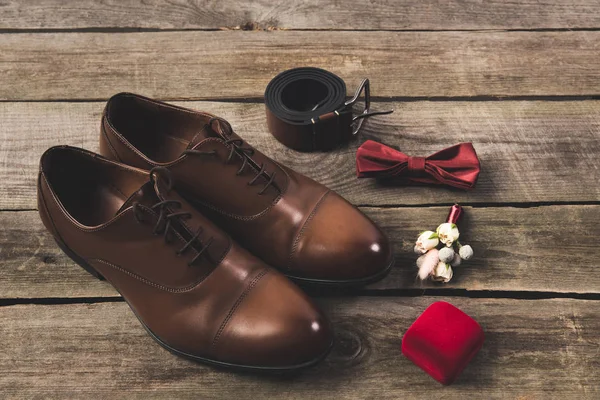 Vista de cerca de los novios dispuestos zapatos y accesorios en la superficie de madera - foto de stock