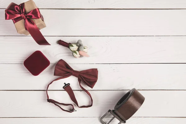 Flat lay with grooms accessories, buttonhole, gift and jewelry box on wooden surface — Stock Photo