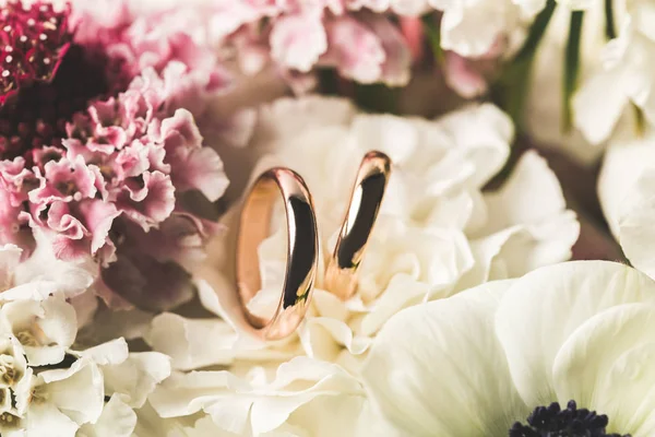 Close up view of wedding rings in bridal bouquet — Stock Photo