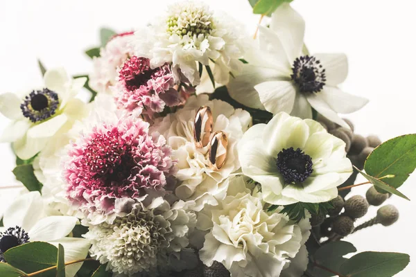 Vista da vicino di fedi nuziali in bouquet da sposa isolato su bianco — Foto stock