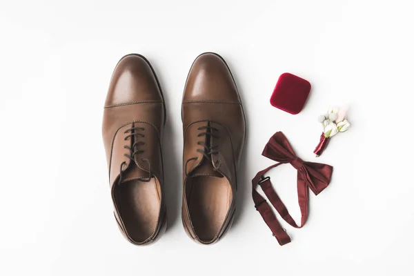 Flache Lage mit Bräutigam Schuhe, Knopfloch, Fliege und Schmuckschatulle isoliert auf weiß — Stockfoto
