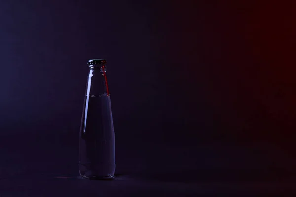 Bottiglia d'acqua chiusa con coperchio sulla superficie scura — Foto stock