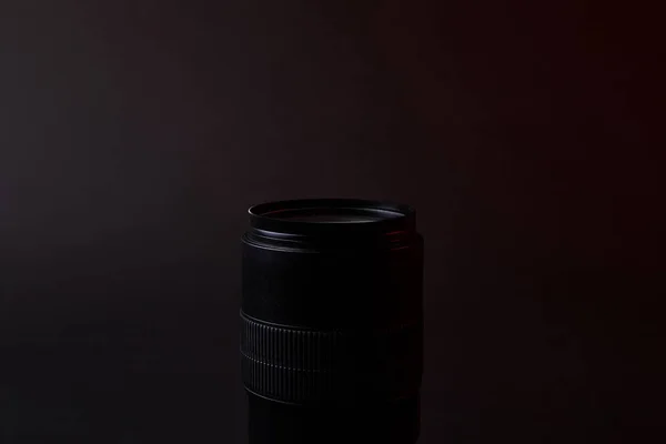 Single optical lens on dark surface — Stock Photo