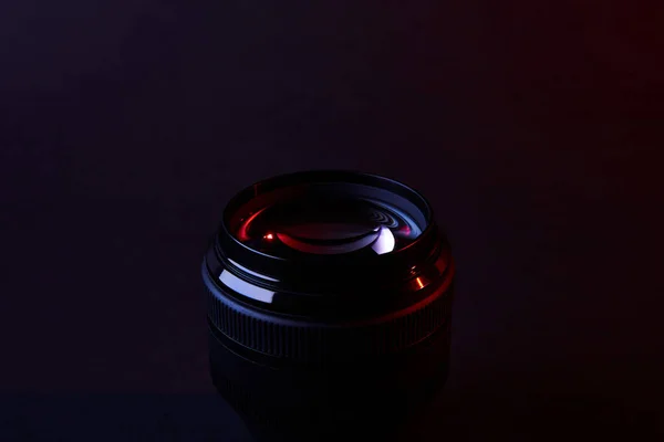 Reflecting camera lens on dark surface — Stock Photo