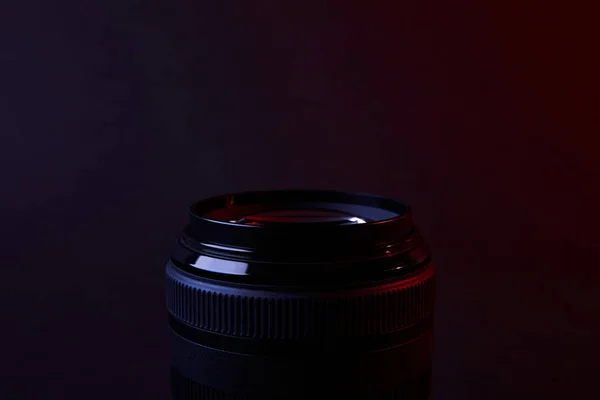Una lente de cámara en la superficie oscura - foto de stock