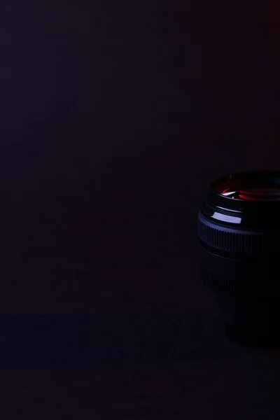 Single camera lens with reflection on dark — Stock Photo