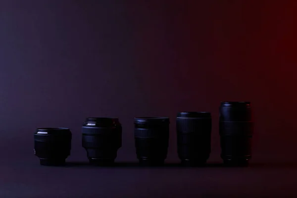 Différentes lentilles de caméra sur la surface sombre — Photo de stock