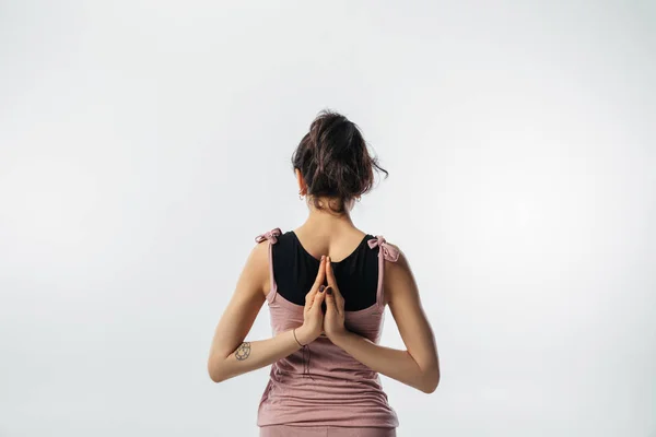 Espalda de mujer practicando yoga con namaste detrás de la espalda aislado sobre blanco - foto de stock