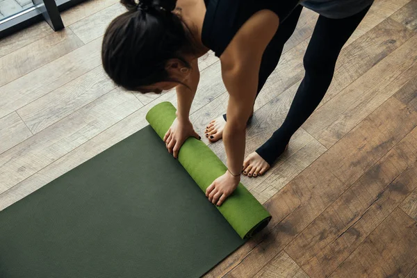 Vue grand angle de fille mettant tapis de yoga sur le sol — Photo de stock