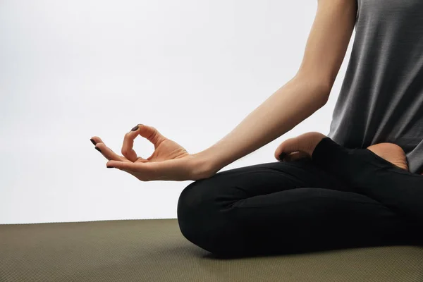 Cropped image of woman meditating in yoga lotus pose isolated on white — Stock Photo