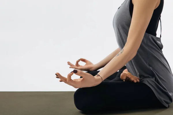 Imagen recortada de la mujer meditando en yoga pose de loto aislada en blanco - foto de stock