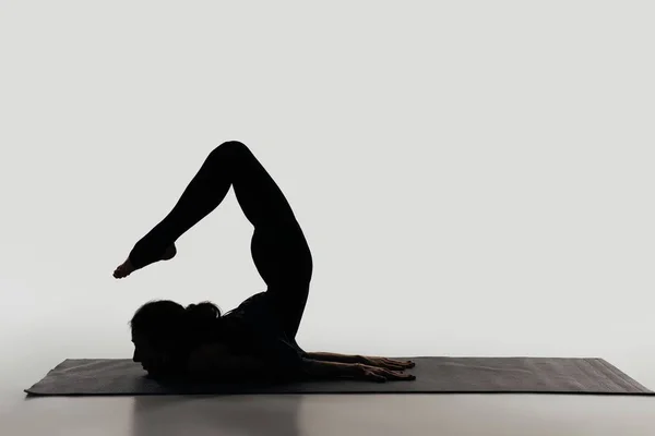 Side view of woman practicing yoga on white — Stock Photo