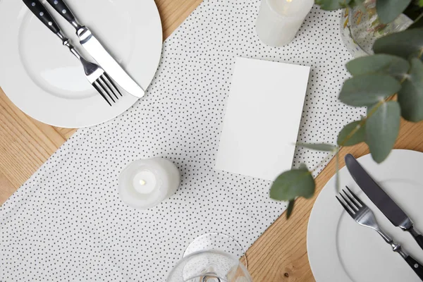 Festtafel mit Besteck auf Tellern auf Tisch mit Kerzen — Stockfoto