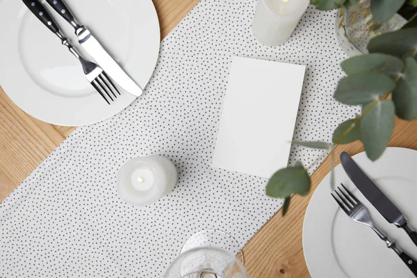 Festive table with cutlery on plates on table with candles — Stock Photo