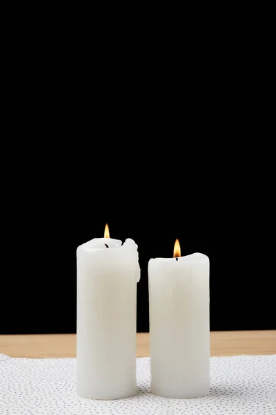 Table with burning candles on black background — Stock Photo