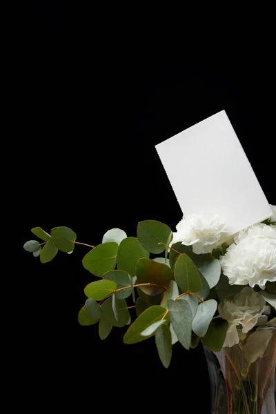 Vase with flower bouquet and empty card isolated on black — Stock Photo