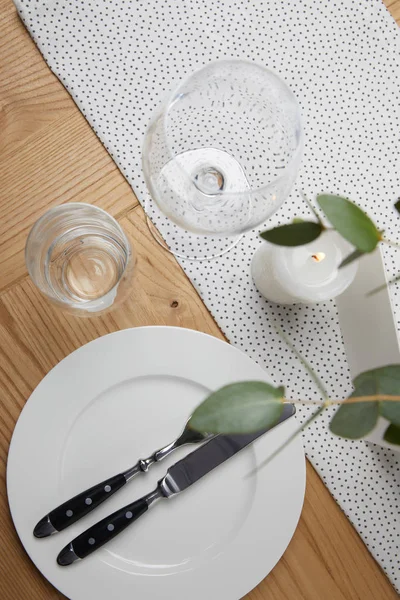 Mesa festiva con cubiertos en plato sobre mesa con vela - foto de stock