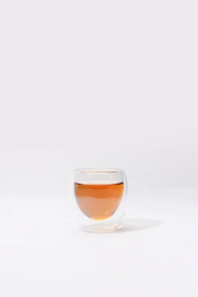 Vue rapprochée de tasse en verre avec tisane fraîche sur gris — Photo de stock