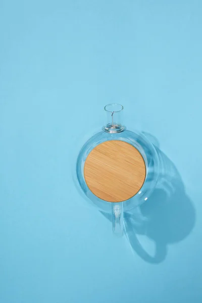 Top view of empty glass teapot on blue — Stock Photo