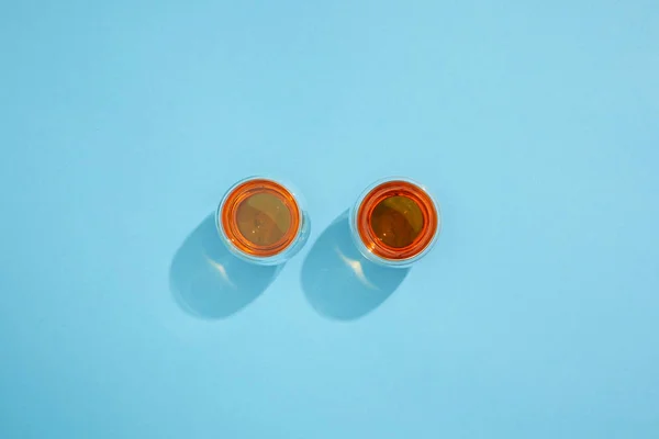 Top view of cups with fresh hot tea and shadows on blue — Stock Photo