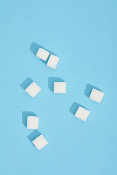 Close-up view of sweet white tasty sugar cubes on blue — Stock Photo