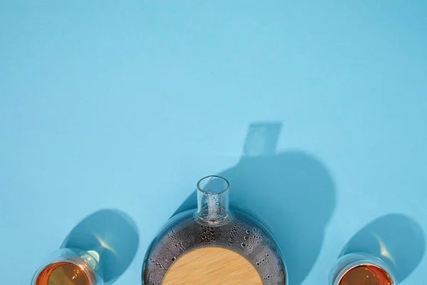 Vue du dessus de la théière et des tasses avec du thé frais sur bleu — Photo de stock