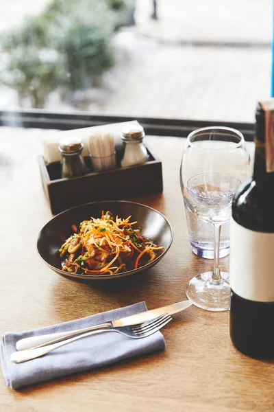 Udon fideos con cerdo servido en la mesa con vino - foto de stock