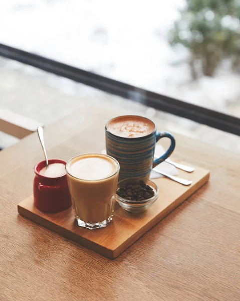 Café caliente con leche en la mesa en la cafetería - foto de stock