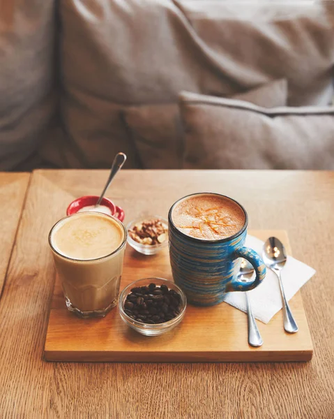 Bebidas de café quente em vidro e xícara com grãos e nozes — Fotografia de Stock