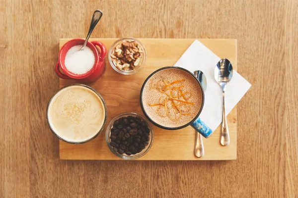 Bebidas de café com nozes na mesa no café — Fotografia de Stock