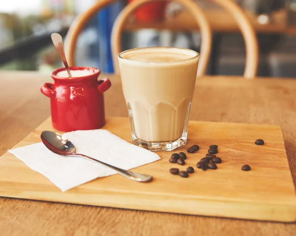 Boisson au café avec haricots sur planche en bois — Photo de stock