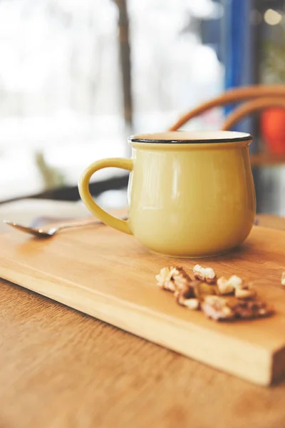 Cacao caliente en taza con nueces servidas sobre tabla de madera - foto de stock