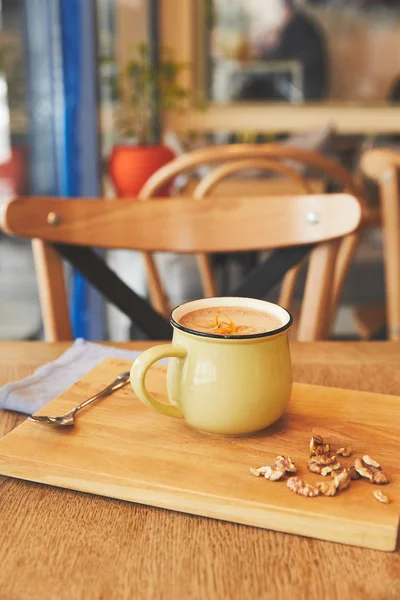 Какао напиток с апельсиновой кожурой и орехами на столе — стоковое фото
