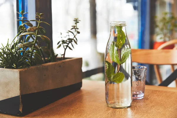 Бутылка с мятной водой и стеклом на столе — Stock Photo