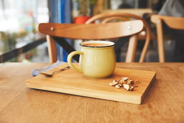 Chocolat chaud dans une tasse avec écorce d'orange servi sur une planche en bois — Photo de stock