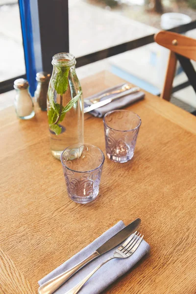 Apparecchiatura della tavola con bicchieri e acqua di menta — Foto stock