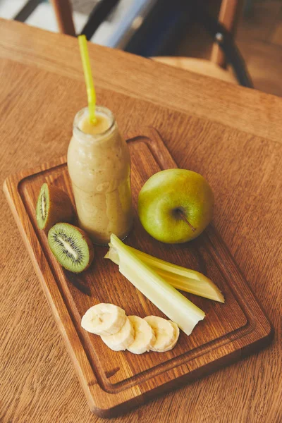 Bouteille avec smoothie aux fruits sur la table dans un café — Photo de stock