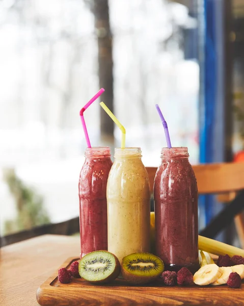 Detox smoothies and raw fruits on table — Stock Photo