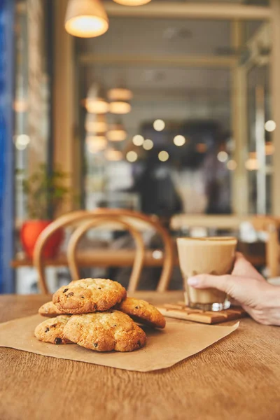 Vidrio de mano con café por galletas - foto de stock