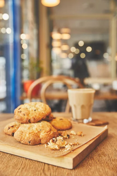 Biscuits maison aux pépites de chocolat sur table en bois avec café blanc plat — Photo de stock