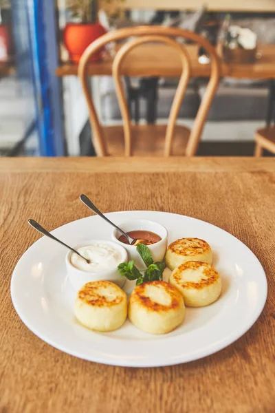 Café da manhã com panquecas de queijo e molhos doces no prato — Fotografia de Stock