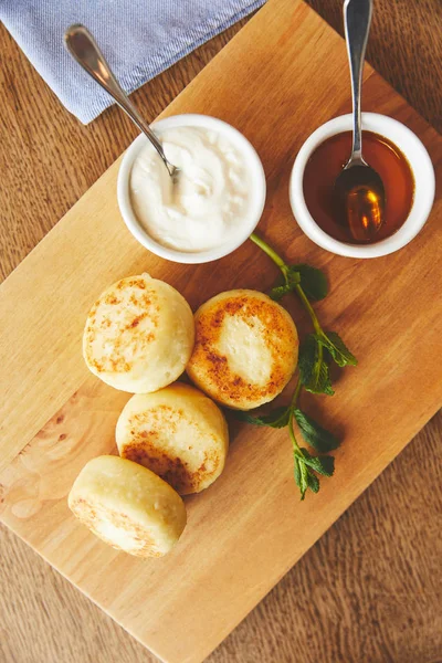 Desayuno con tortitas de queso y salsas dulces - foto de stock