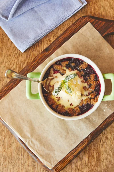 Crumble de bayas servido en olla en la mesa - foto de stock